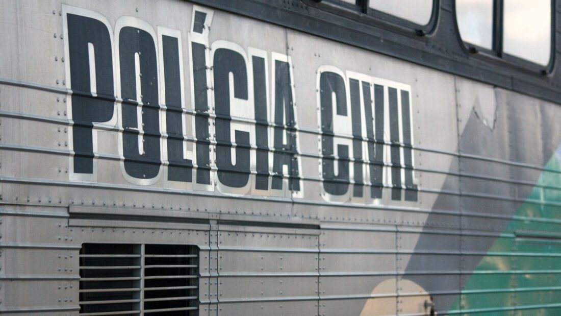 Lateral de um ônibus prateado com a inscrição Polícia Civil em letras pretas