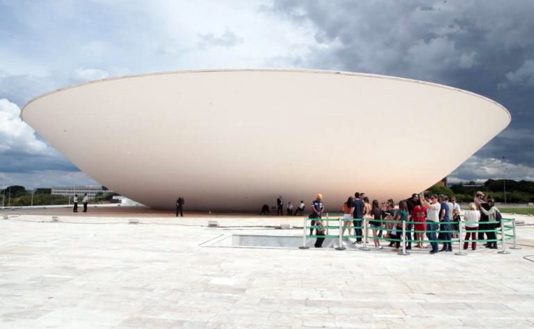 Grupo de visitantes diante da cúpula da Câmara dos Deputados, no Congresso Nacional, em Brasília