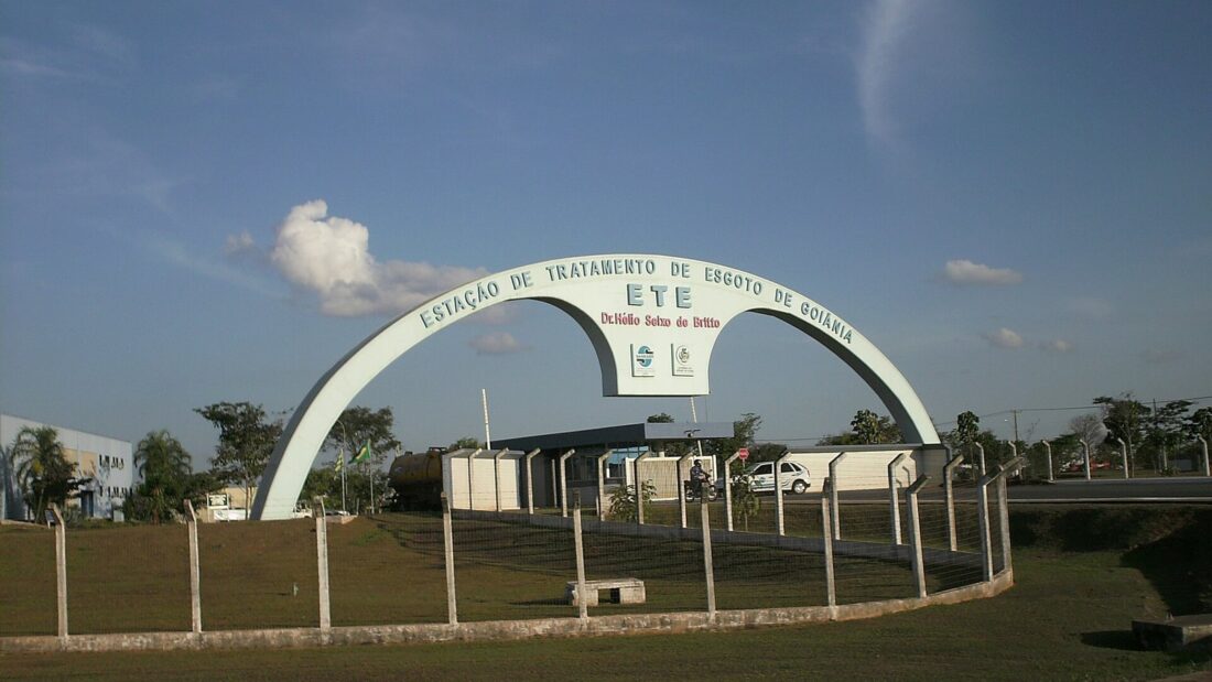 Arco de entrada da Estação de Tratamento de Esgoto de Goiânia, com gramado e prédios da estação ao fundo