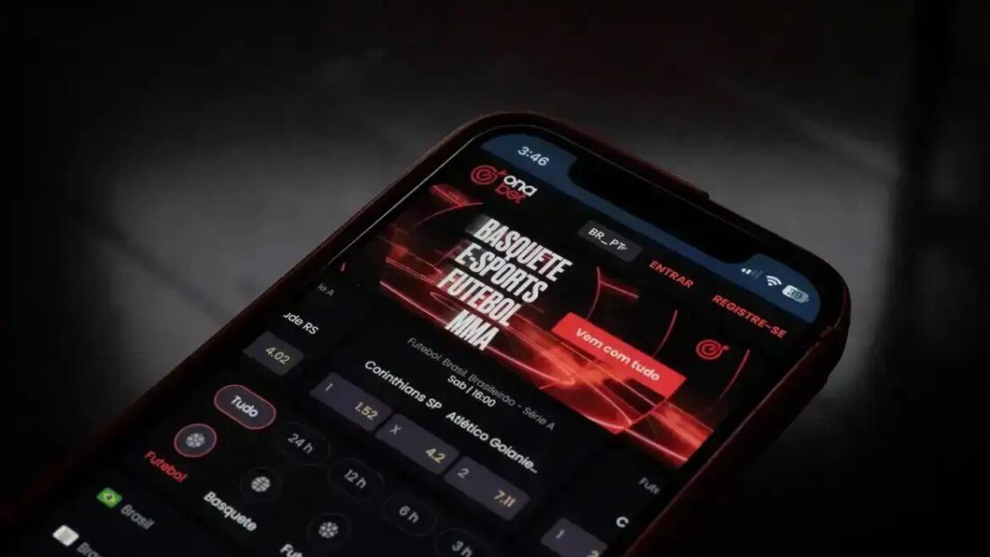 Tela de celular com aplicativo de apostas esportivas aberto, em fundo escuro, mostrando opções de basquete, futebol, e-sports e MMA