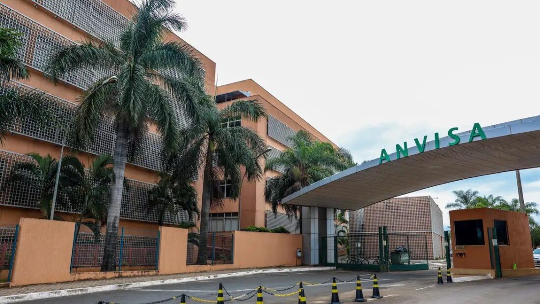 Fachada do prédio da Anvisa em Brasília, com o letreiro da agência na cobertura da portaria e palmeiras ao lado