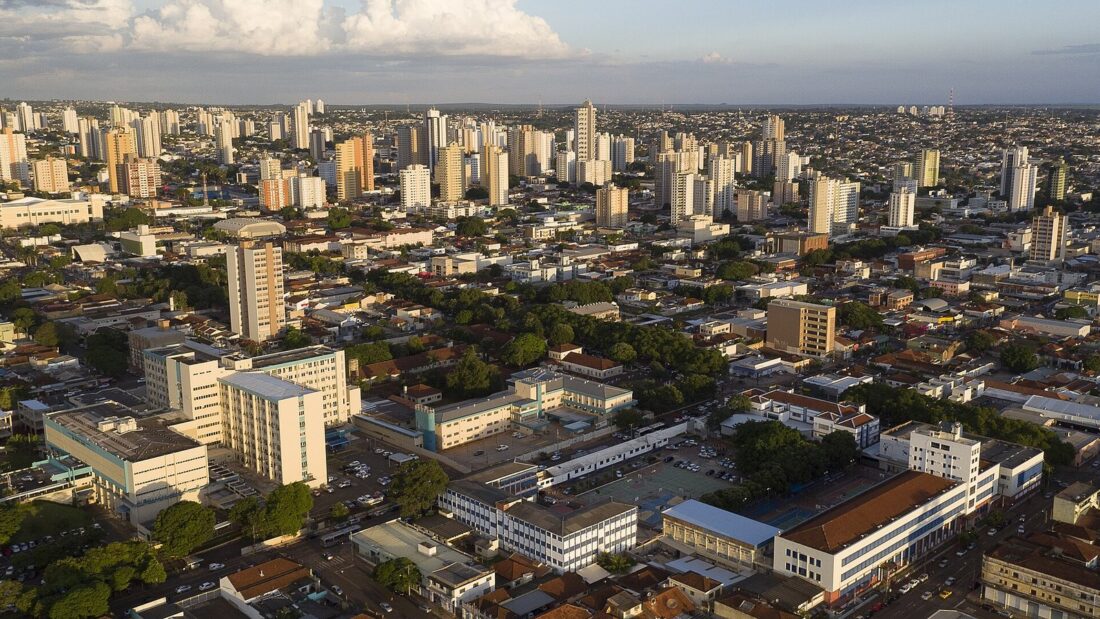 Vista aérea da região central de Campo Grande, com prédios baixos em primeiro plano e torres residenciais ao fundo
