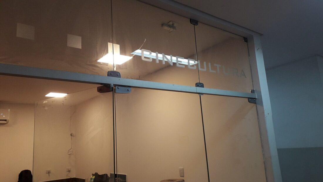 Entrada envidraçada do Cine Cultura, em Goiânia, com o nome da sala em letras metálicas sobre o vidro
