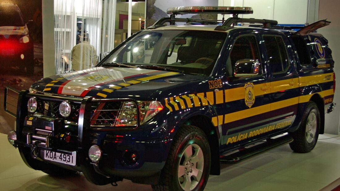 Caminhonete da Polícia Rodoviária Federal, azul-escura com faixas amarelas, exposta em um salão