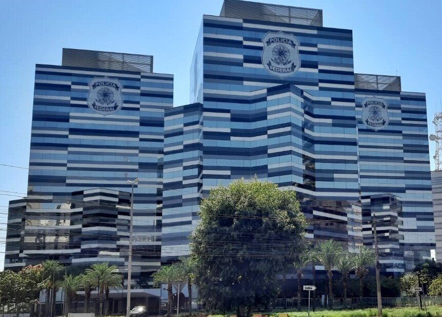Fachada espelhada do edifício-sede da Polícia Federal, em Brasília, com o brasão da corporação