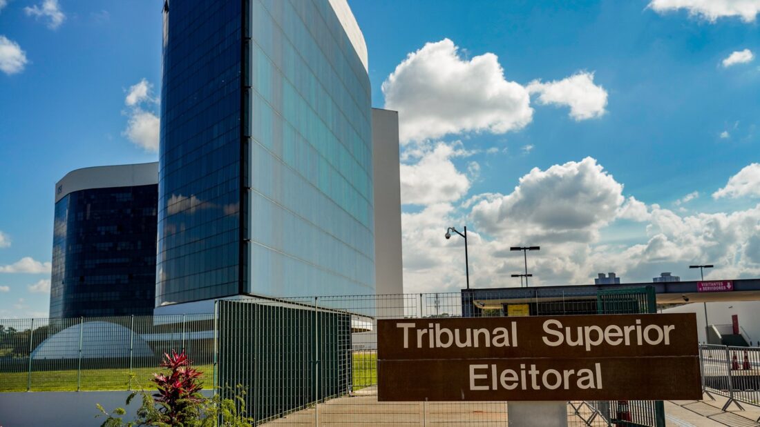 Fachada espelhada da sede do Tribunal Superior Eleitoral, em Brasília, com placa de identificação