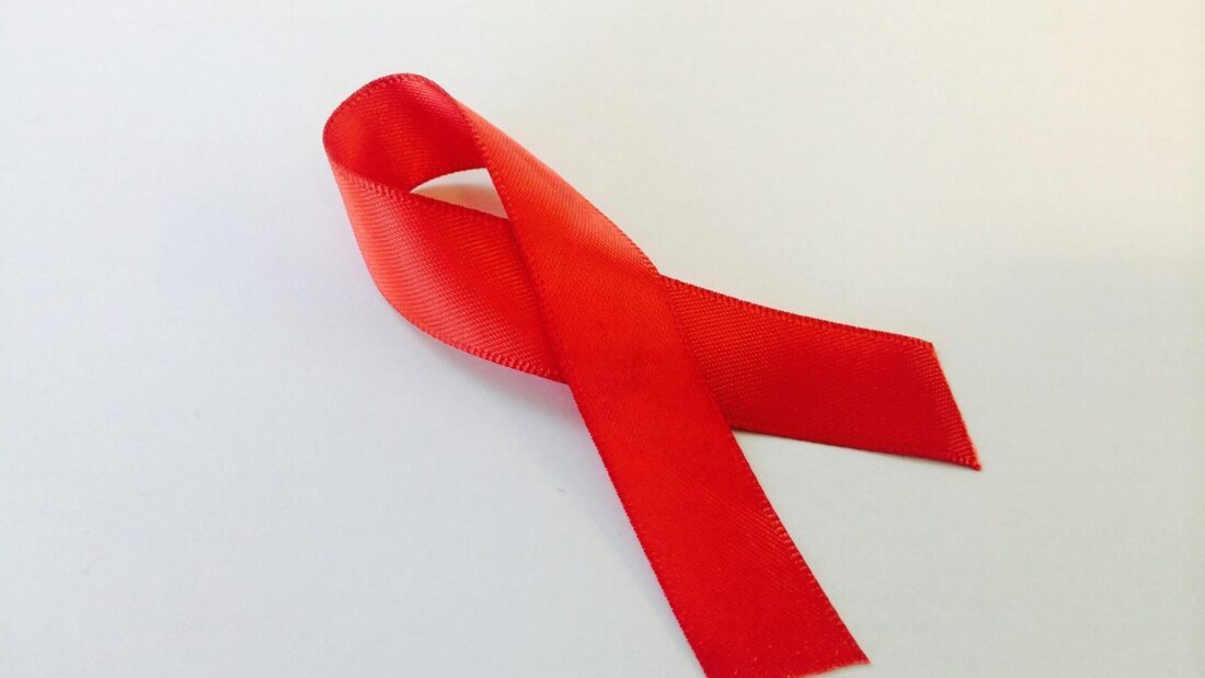 Laço de fita vermelha sobre fundo branco, símbolo internacional da luta contra a aids