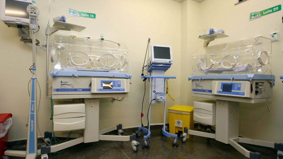 Sala de UTI neonatal com duas incubadoras e monitores, sem pacientes