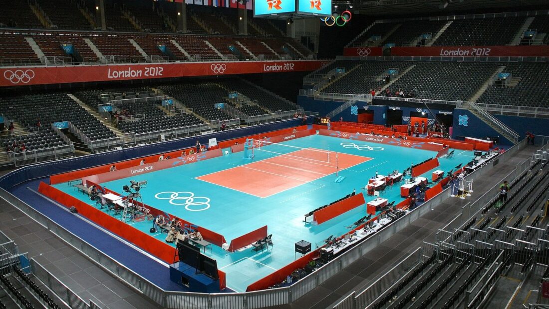 Quadra de vôlei laranja e azul vista do alto de uma arena vazia