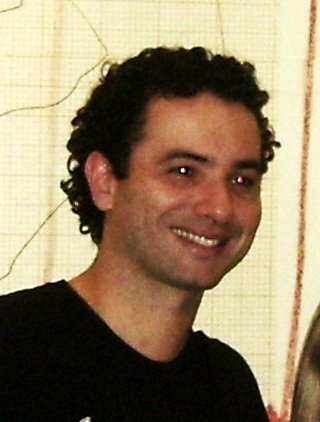 O humorista Marco Luque sorri, de camiseta preta, em foto de 2011