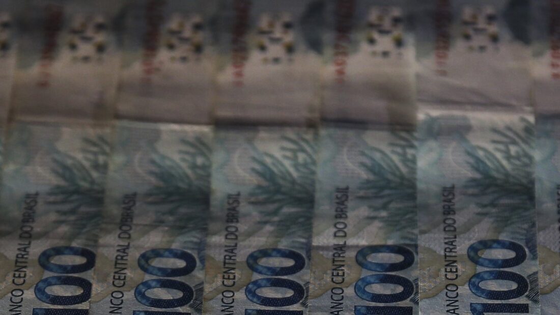 Cédulas de 100 reais enfileiradas
