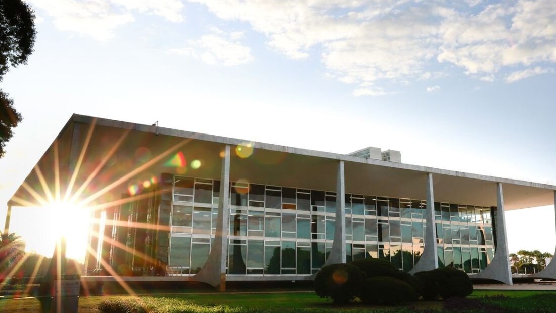 Fachada do Supremo Tribunal Federal, em Brasília, com as colunas brancas do edifício e o sol baixo ao fundo