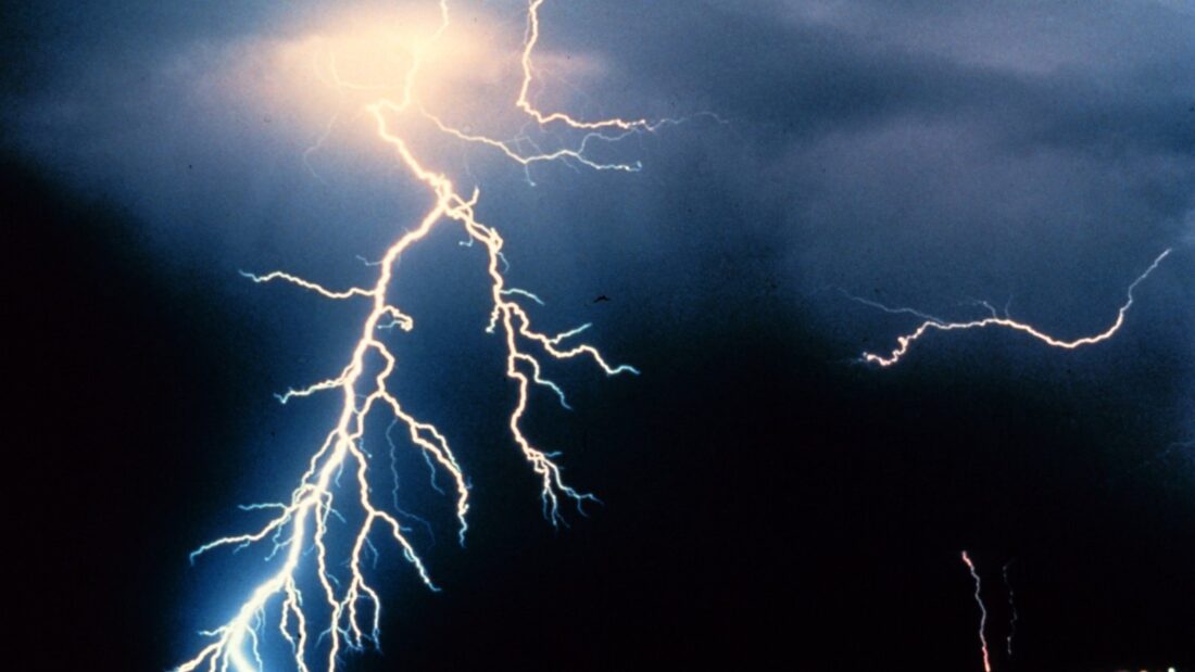 Vários raios cortam o céu escuro durante uma tempestade noturna