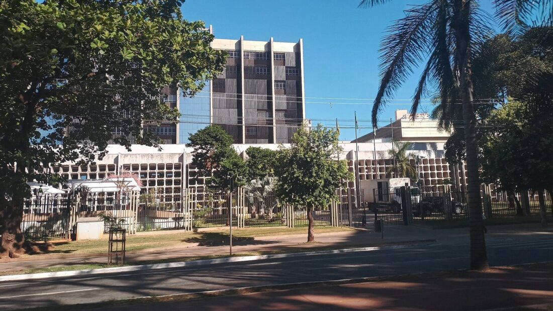 Prédio do Tribunal de Justiça de Goiás, em Goiânia, com fachada de vidro e concreto em vários andares, árvores e palmeiras na frente