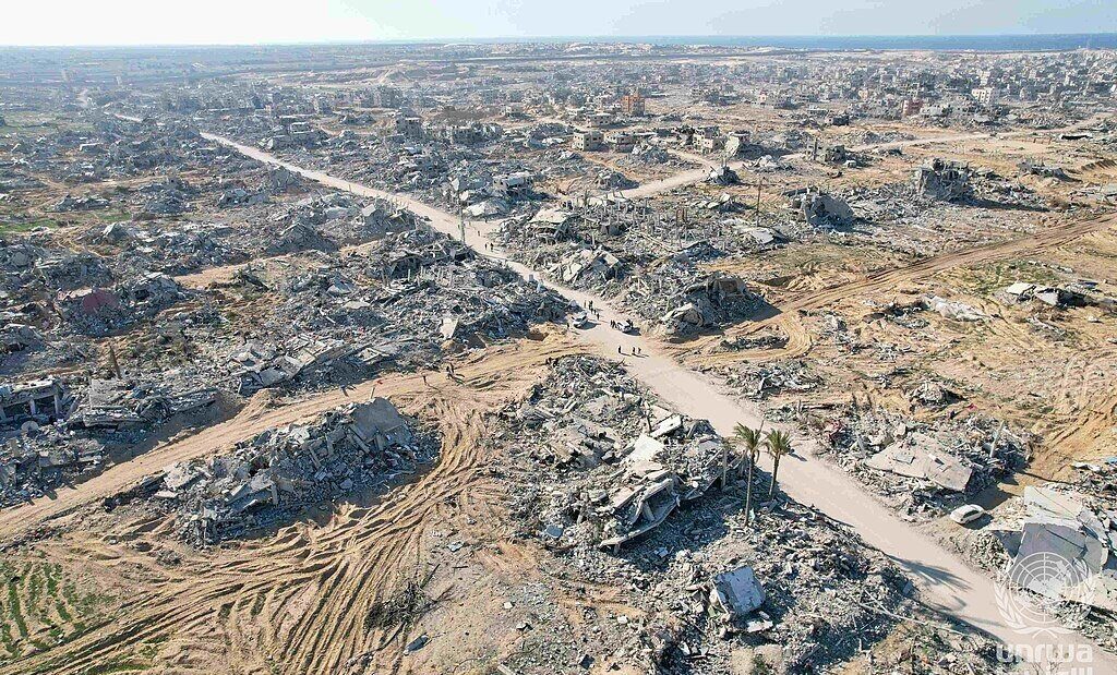 Vista aérea de quarteirões inteiros reduzidos a escombros em Rafah, com ruas de terra abertas entre os destroços