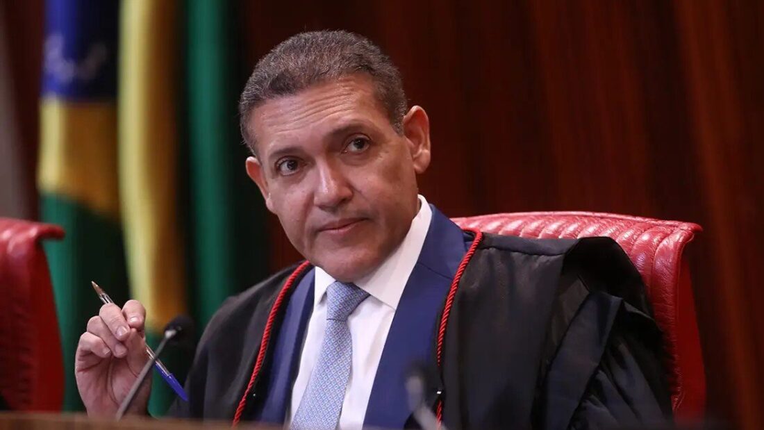 Ministro Kassio Nunes Marques, de toga, sentado na cadeira da presidência do plenário do TSE